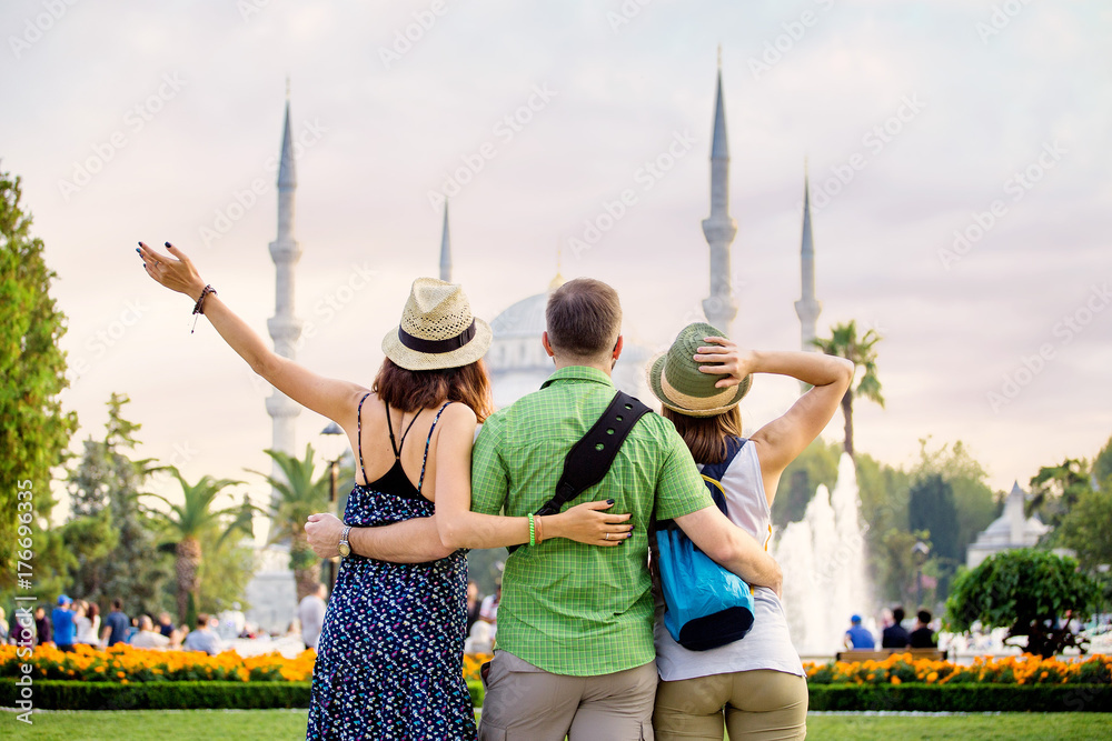 Fototapeta premium Group of Friends hugging and looking at Istanbul great Blue Mosque. Student travel in Turkey concept