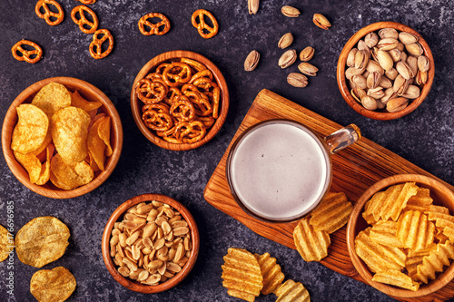Beer with snacks on stone background.
