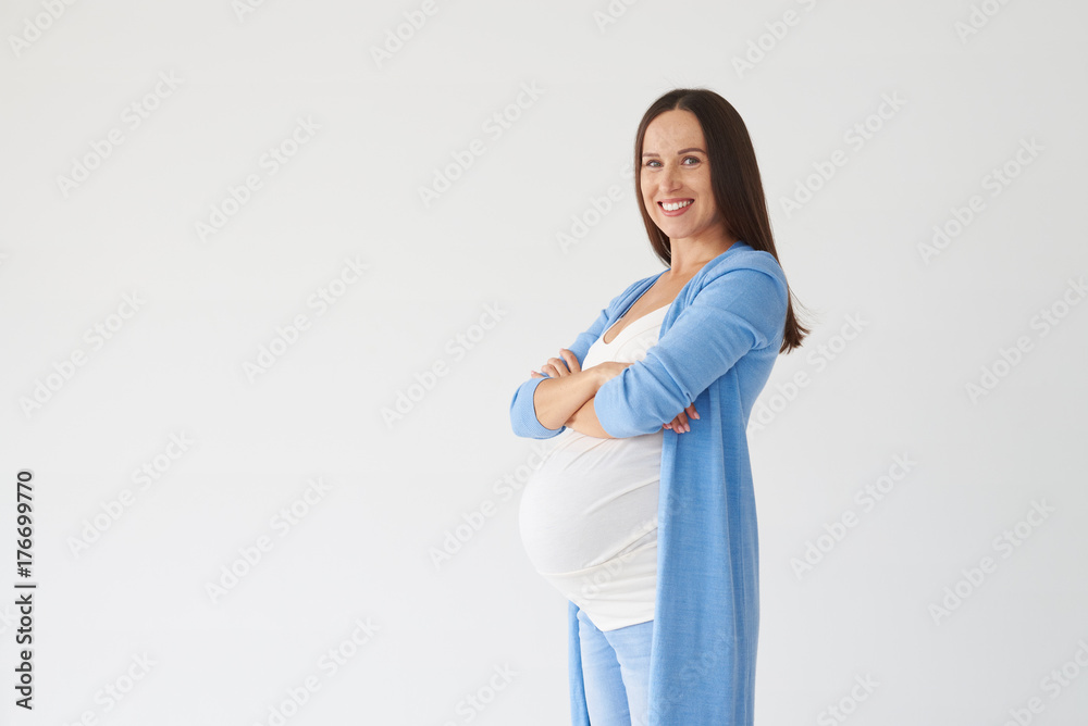 Pregnant woman folded hands against white background Pregnant woman folded hands against white background