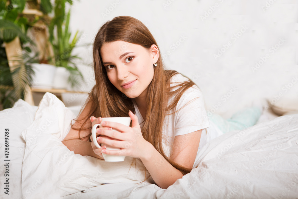 Happy girl  drinking coffee on bed in the morning in home