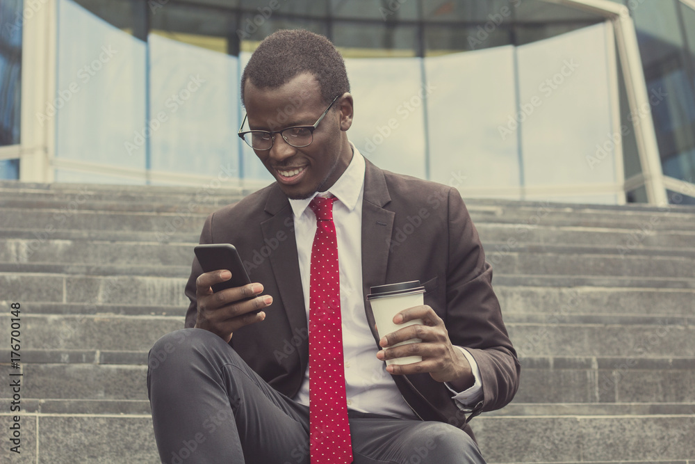 Fotografie Urban photo of young handsome African American business guy spending leisure tim