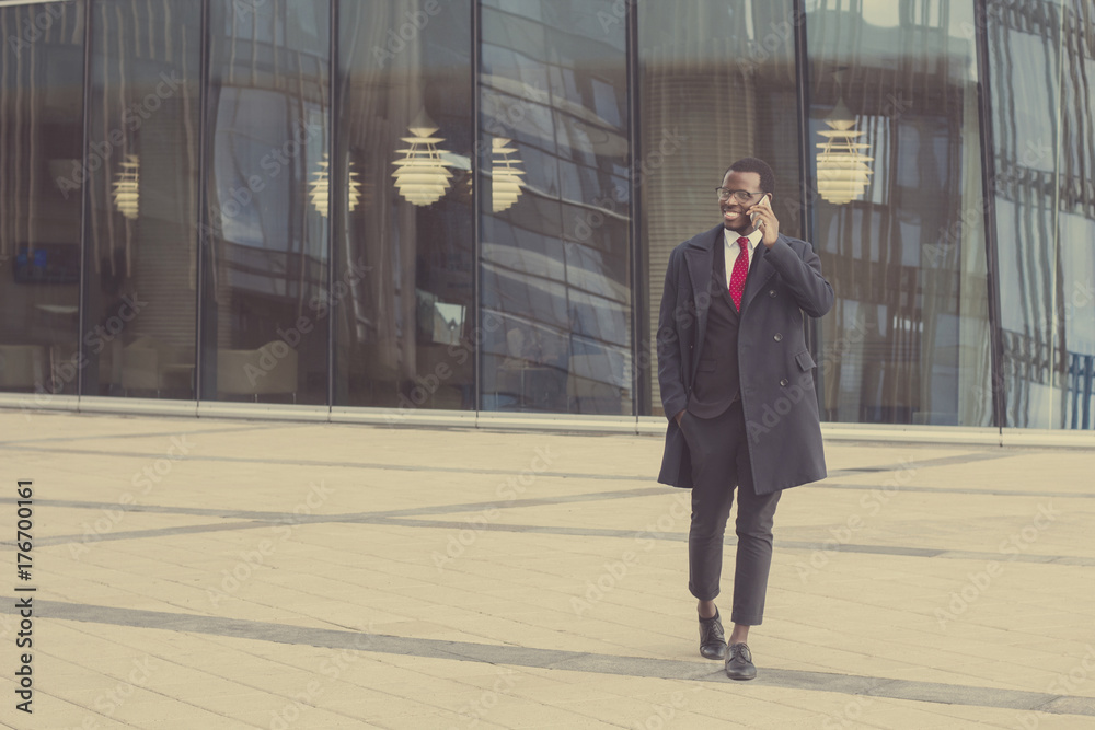 Φωτογραφία Full-length portrait of young African American entrepreneur walking on pavement