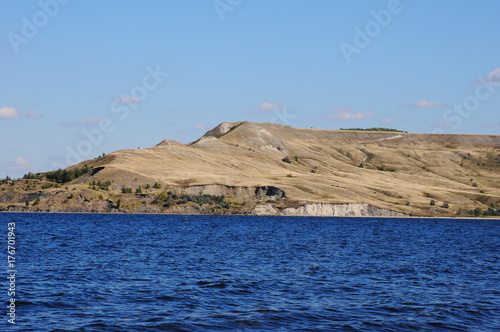 Landscape by the water. Island on the other side. Bay, blue water with waves. River or sea