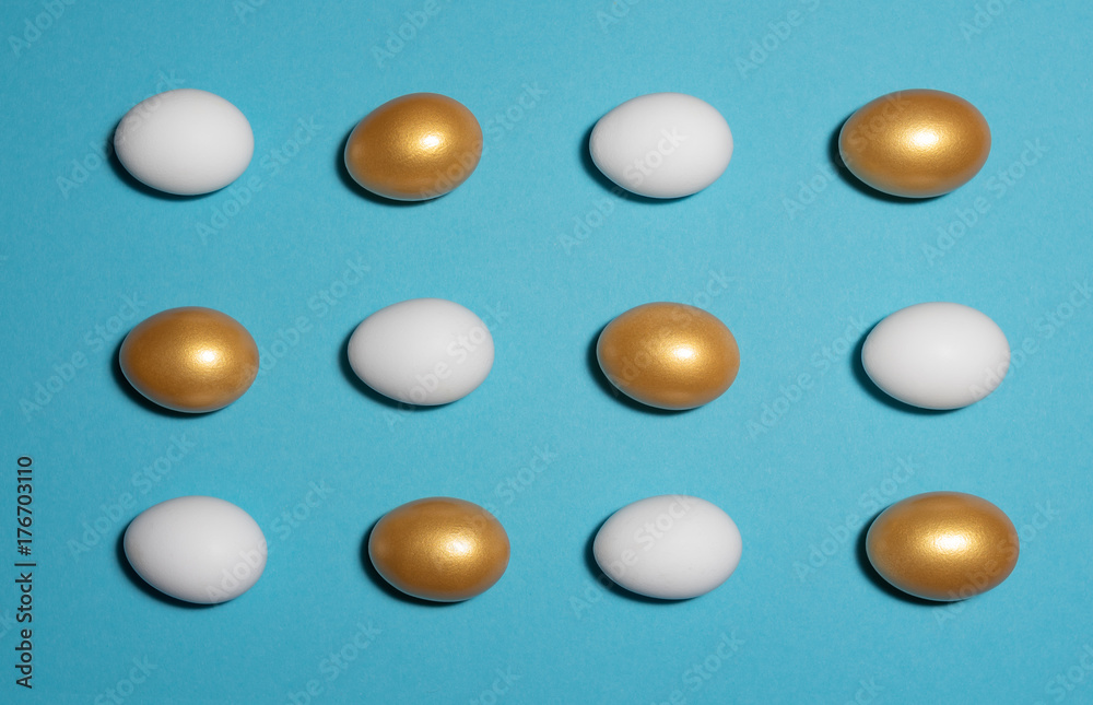 Concept of individuality, exclusivity, better choice. Pattern of white and gold eggs on blue background. Concept of individuality, exclusivity, better choice. Pattern of white and gold eggs on blue background.