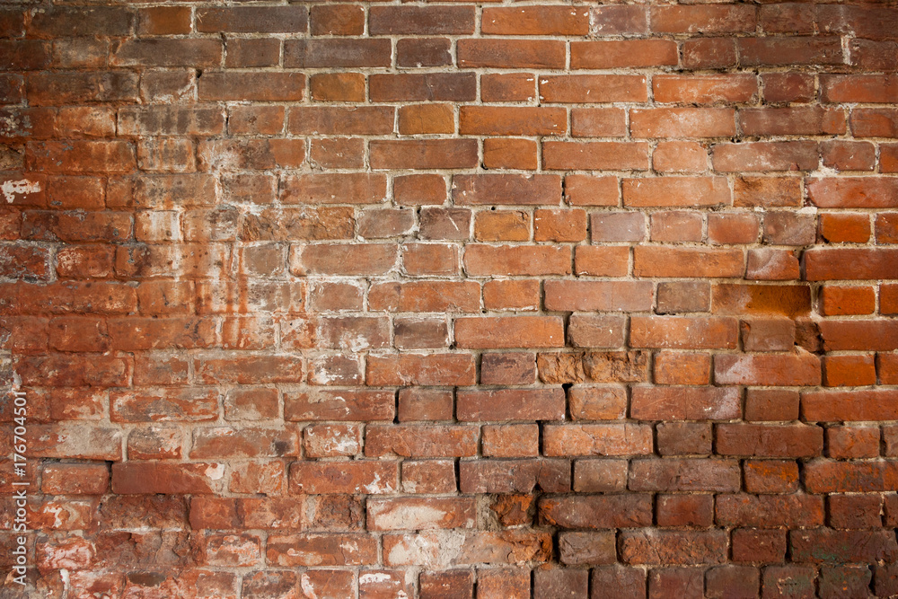 Fototapeta premium A close-up shot of the old rough brick masonry wall lined with red clumsy brick for creativity, textures and background.