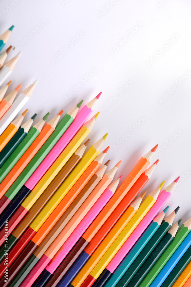 Colored crayons background. Many different colored pencils on white background