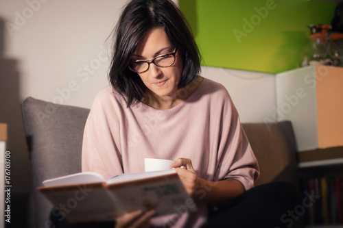 Beautiful woman reading book during coffee time.