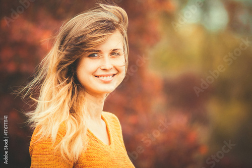 autumn portrait of a female face against a background of orange foliage in the park