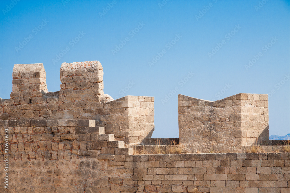 view of medieval castle’s wall on the background of blue sky, Rhodes, Greece