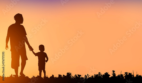silhouette family walking on blurry colorful sky at sunset time 