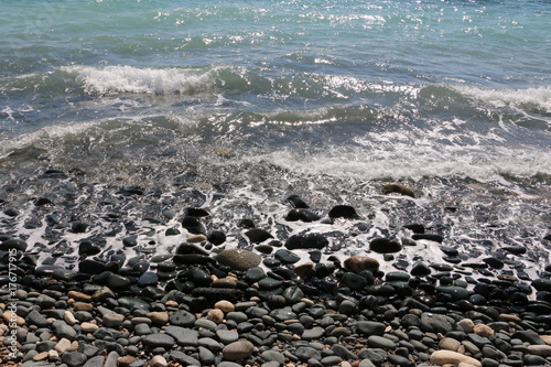 Steiniger Küstenstrand mit lebendigem Meer