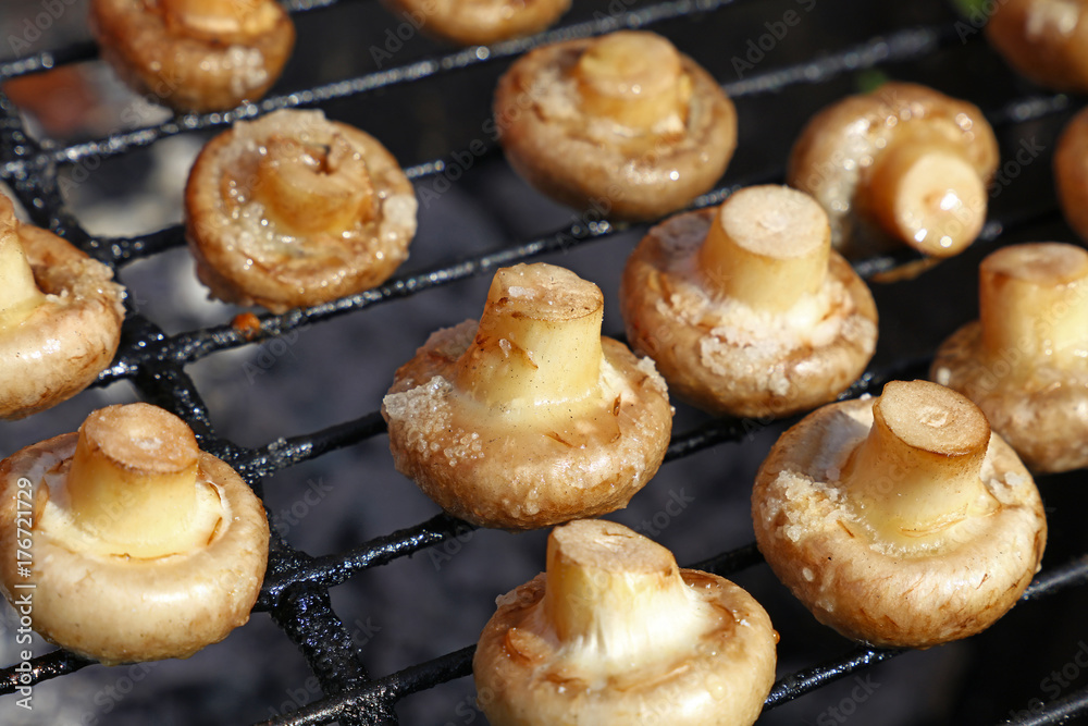White champignons mushrooms on grill White champignons mushrooms on grill