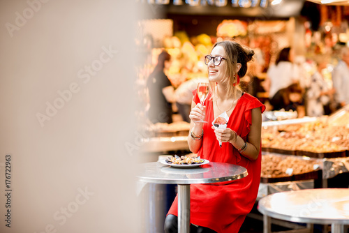 Photography Young woman in red dress eating jamon traditional spanish dry-cured ham sitting