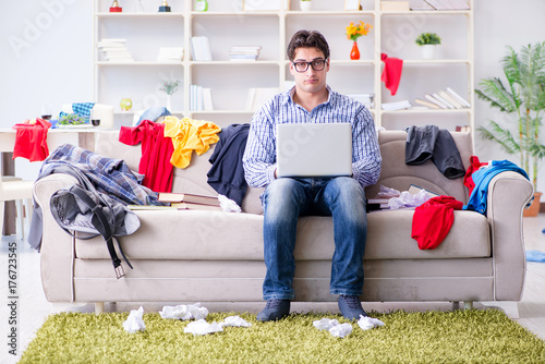 Young man working studying in messy room