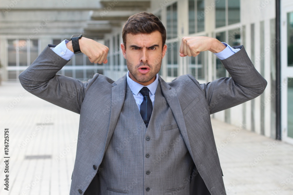 Elegant funny businessman flexing his muscles Elegant funny businessman flexing his muscles