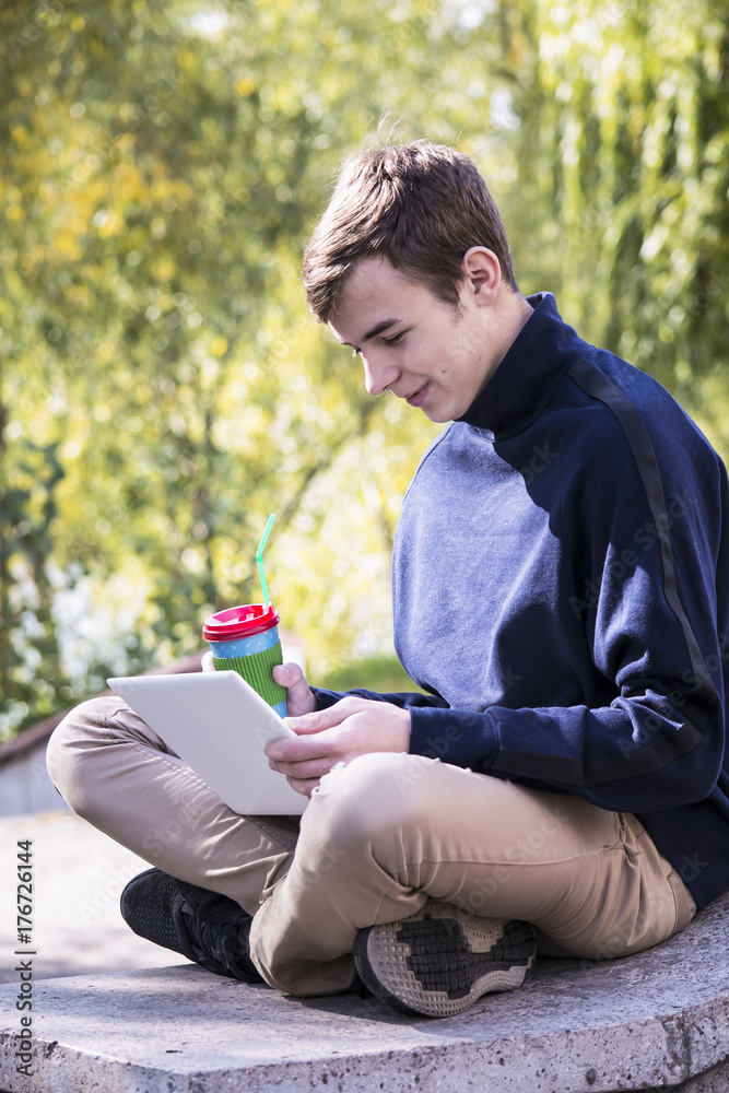 Obraz premium Teenager outdoors in town working laptop