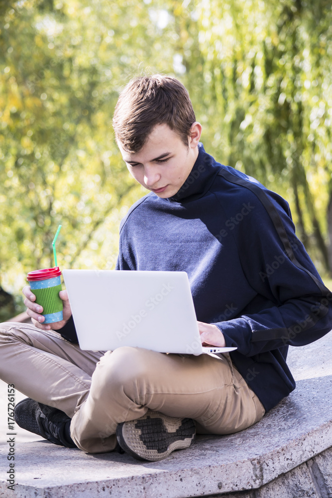 Teenager outdoors in town working laptop Teenager outdoors in town working laptop