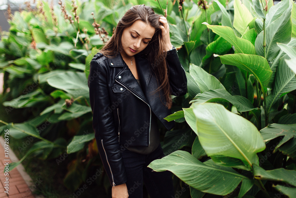 Stylish woman stand near green leaves Stylish woman stand near green leaves