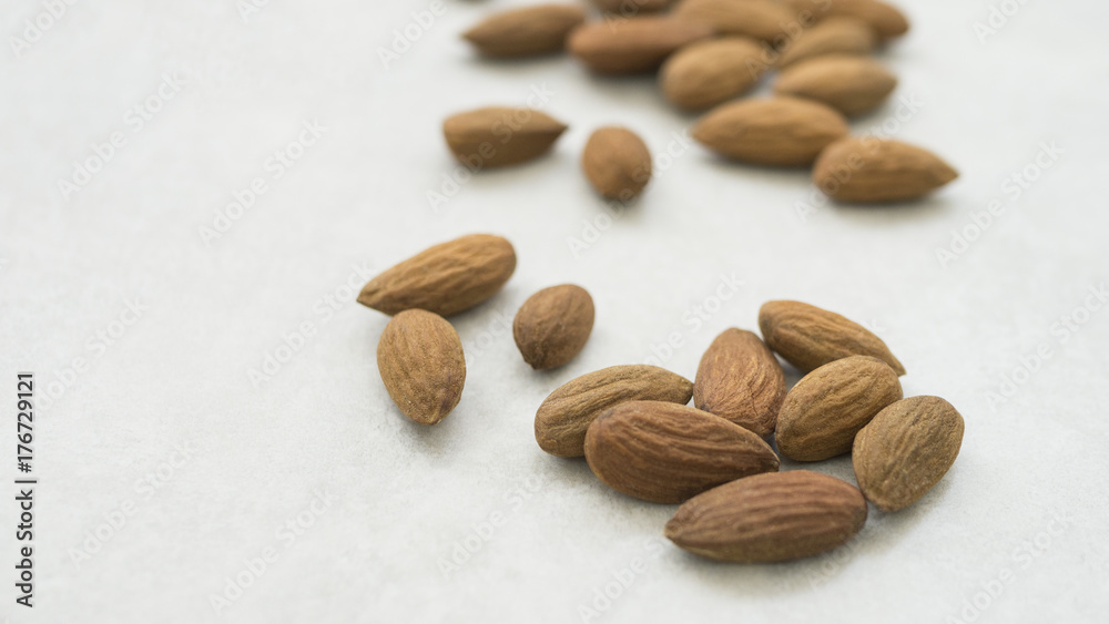 dried almonds on white grey background dried almonds on white grey background