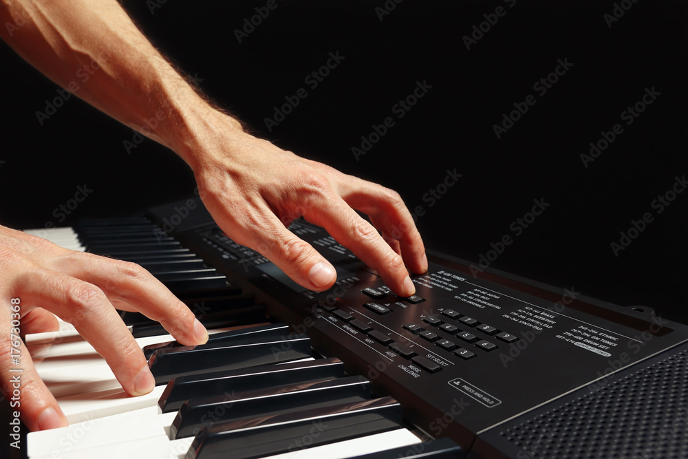 Hands of pianist play the keys of the synth on a black background Hands of pianist play the keys of the synth on a black background