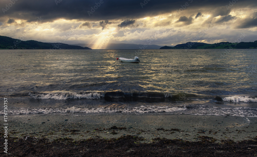 Obraz premium Fishing Boat on Sea with Sunrays in Distance