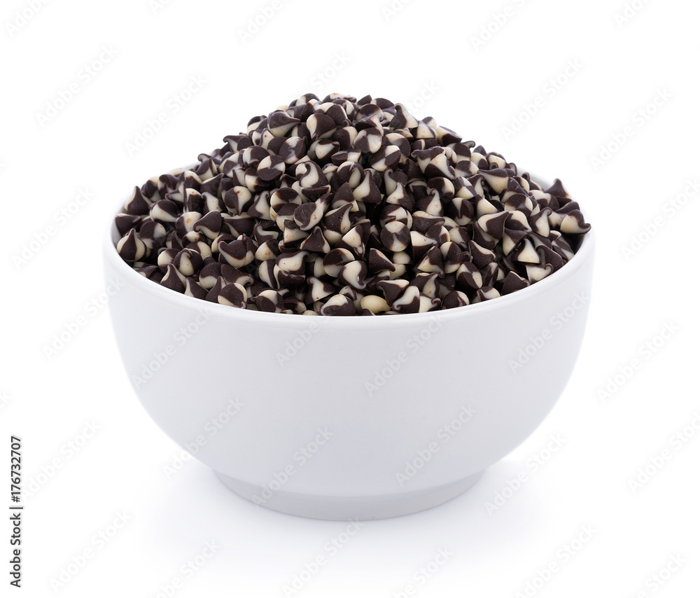 Chocolate chip morsels spread in bowl on white Chocolate chip morsels spread in bowl on white