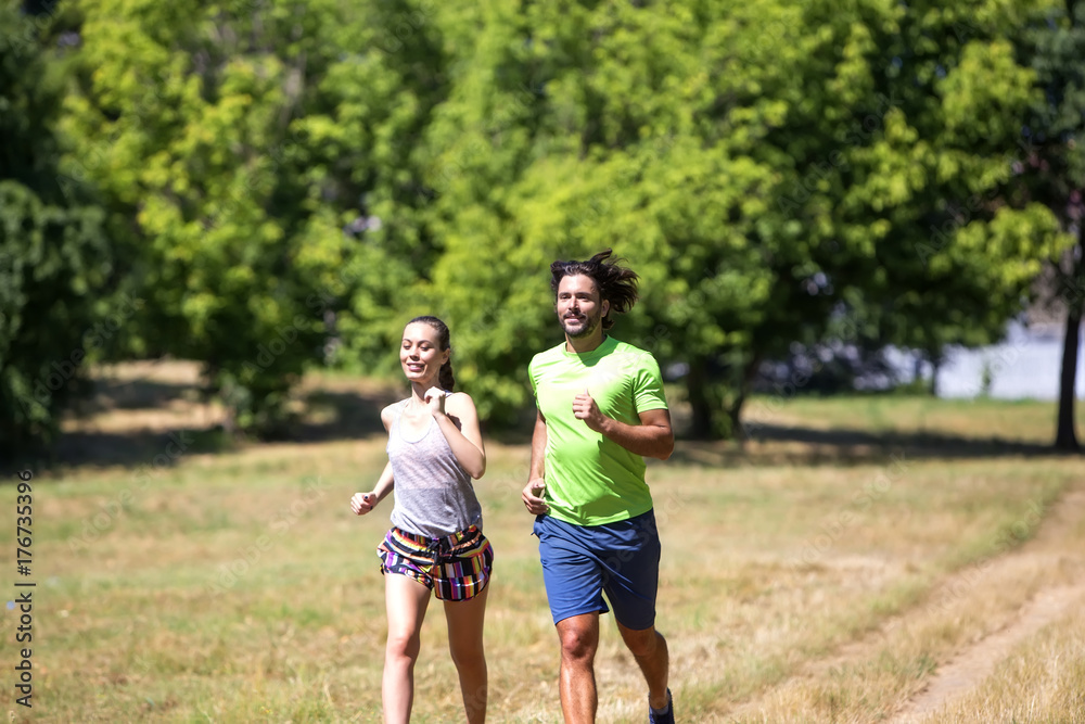 Healthy, fit and  sportive couple running in park