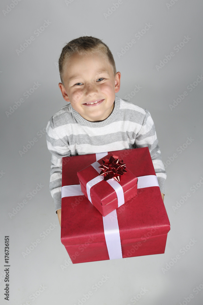 little boy with two red presents in his hands in front of a white background little boy with two red presents in his hands in front of a white background