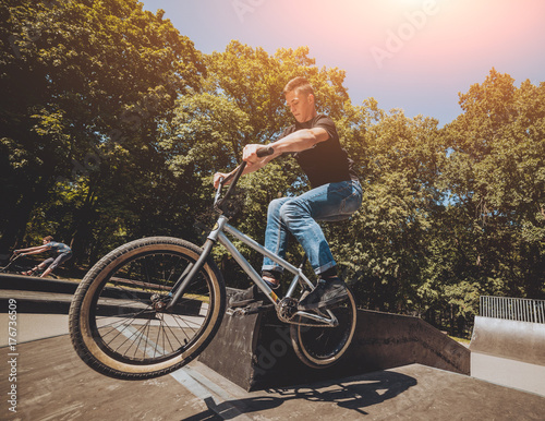Bmx rider performing tricks at skatepark. © romaset