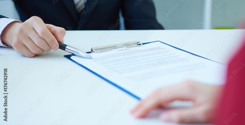 Closeup of businessman's hands showing  his new business partner the terms of the agreement or contract. Selective focus.