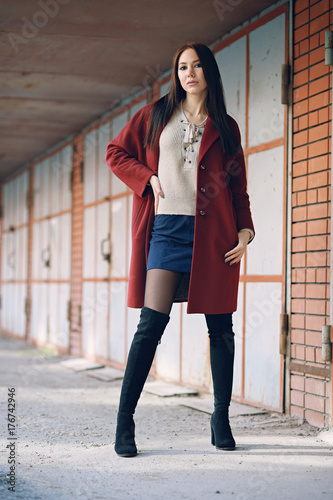 young beautiful stylish woman in claret coat, street style, spring summer trend, dark skirt, beige sweater, flirty © alexsfoto