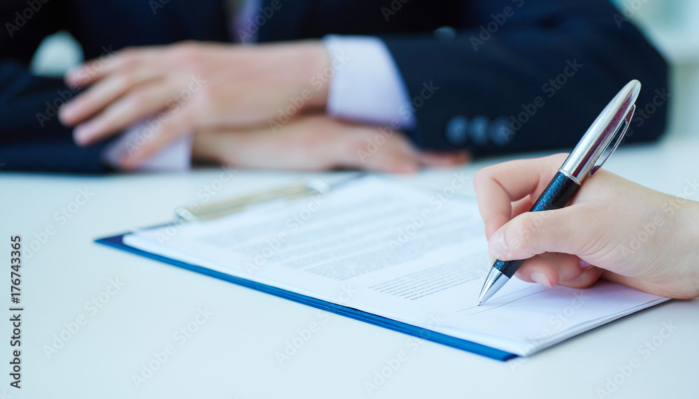 Hands of business woman signing the contract document with pen on desk. selective focus image on sign a contract.