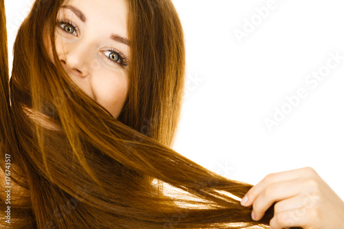 Woman having face covered with her brown hair