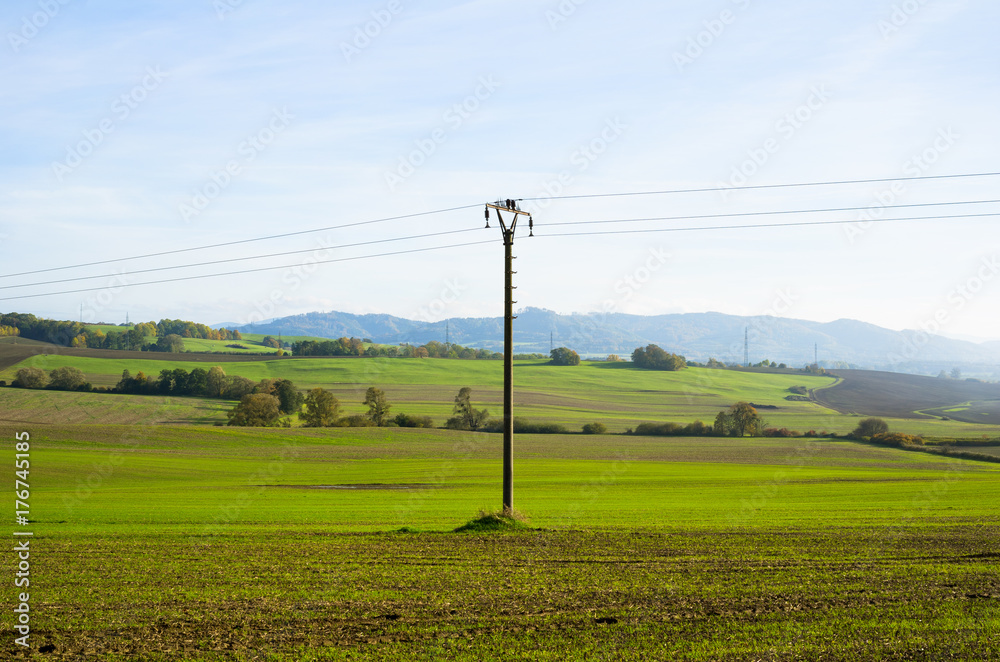Meadow and field around Brusperk, Moravia, Czech Republic - beautiful countryside with green grass and trees. Beskid mountains in the distance. Electric pole in the center