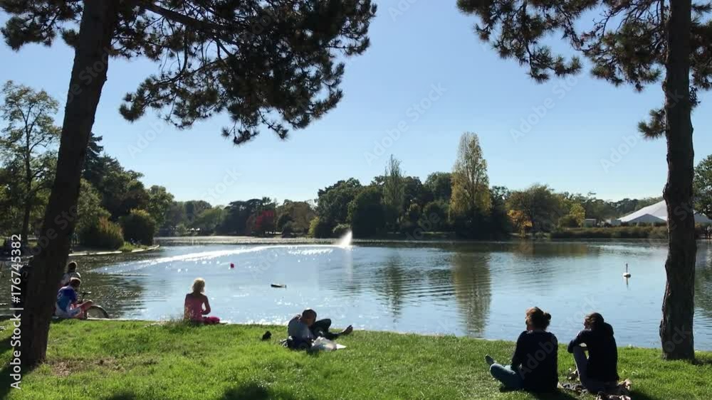 Parisiens au soleil sur une pelouse du Bois de Boulogne à Paris