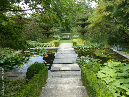Passaggio fra pozzi d'acqua nel giardino di Castillon in Normandia, Francia.