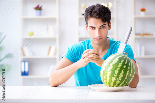 Man eating watermelon at home