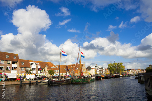 Netherlands Leiden Galgewater, a bright sunny day with a clear blue sky and clouds and with houses along side the Galgewater canal with boats resting in the water. photo