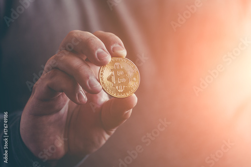 Cryptocurrency golden bitcoin coin in man hand
