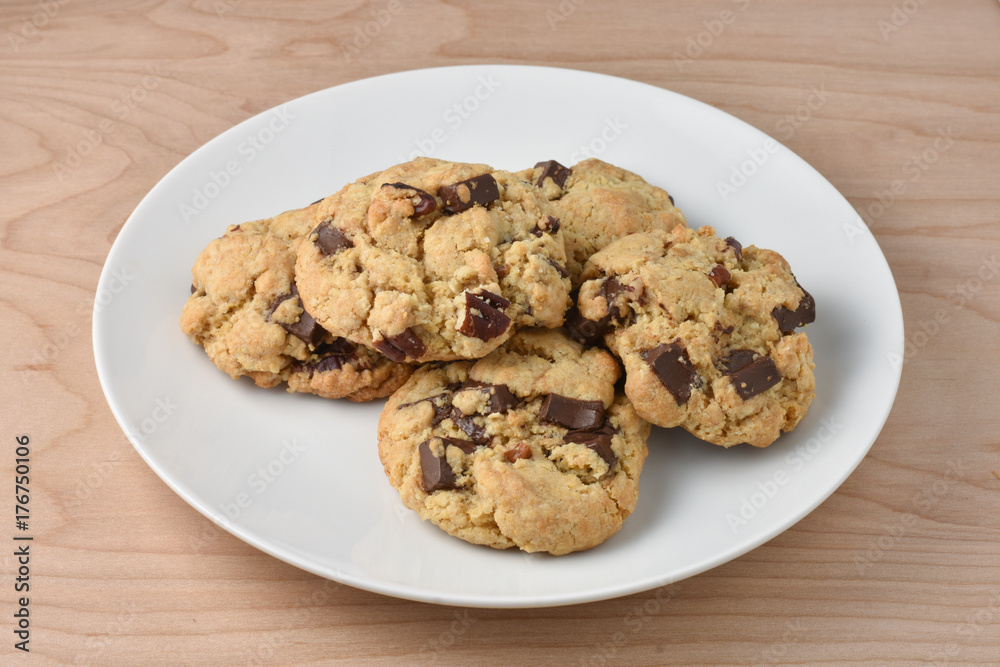 Plate of Chocolate Chip Cookies with dark chocolate chunks on a wooden table Plate of Chocolate Chip Cookies with dark chocolate chunks on a wooden table