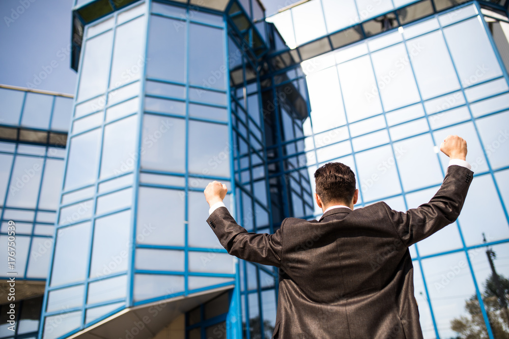 Cheerful Business Man Celebrating Success Outdoors of his office with rised hands