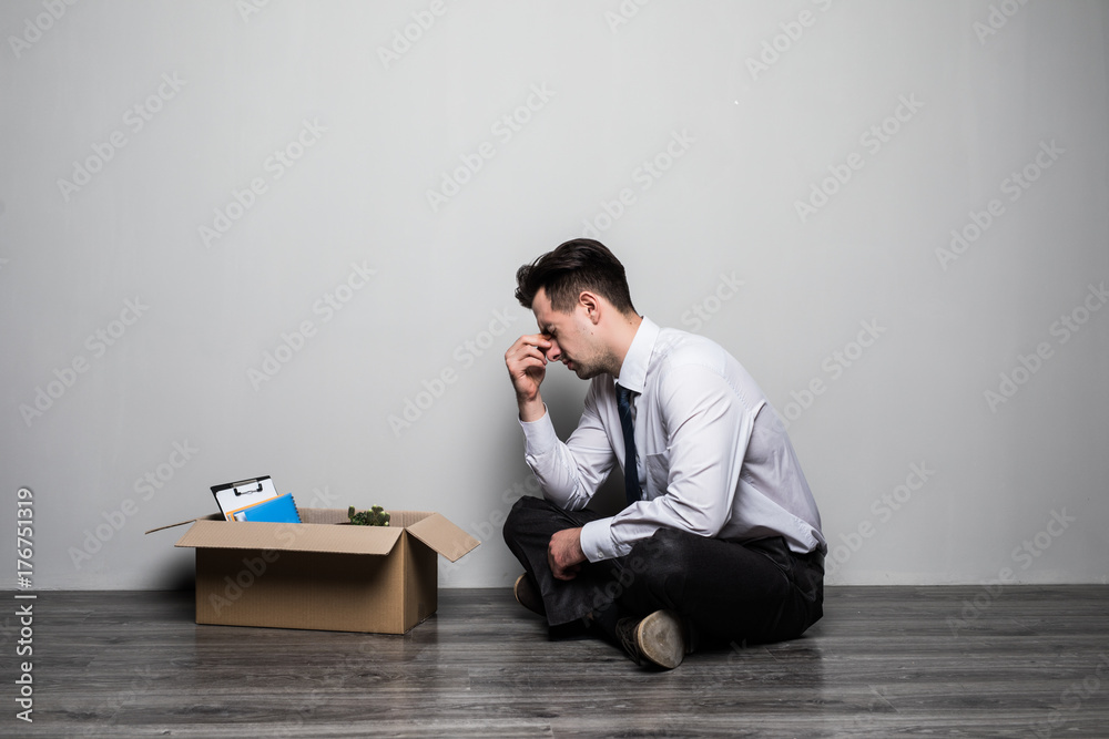 Obraz premium Fired frustrated man in suit sitting on floor in office. Sad