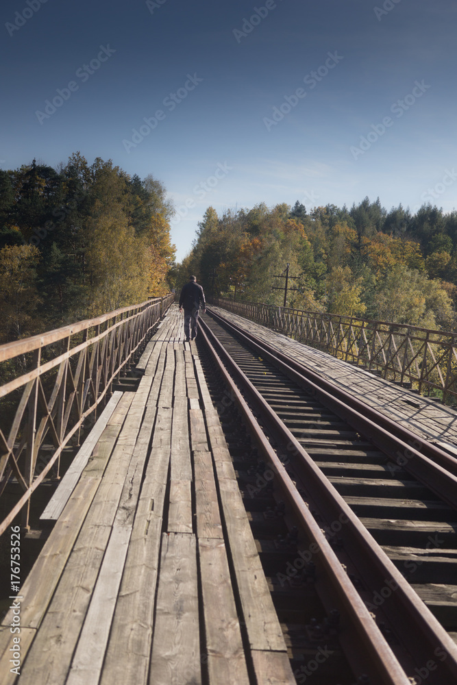 a lonely unidentified man walks over the old train bridge a lonely unidentified man walks over the old train bridge