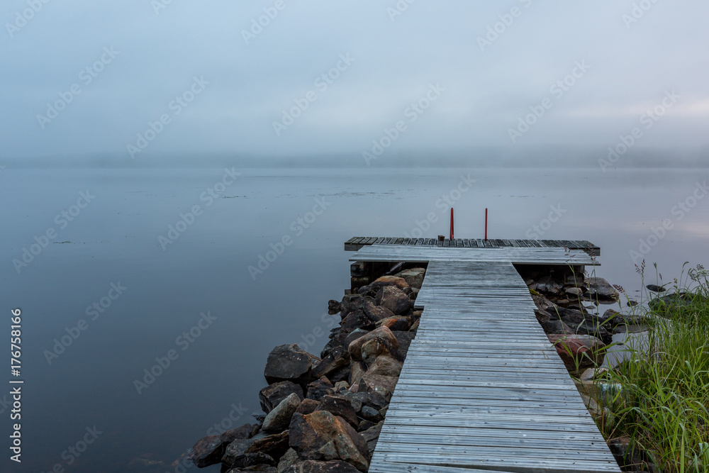 Foggy morning on the lake with pier on foreground Foggy morning on the lake with pier on foreground