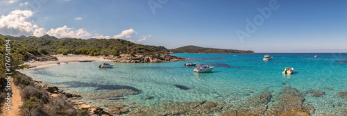Boats in a small rocky cove with sandy beach in Corsica