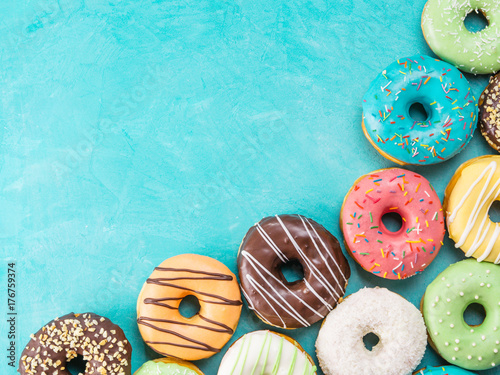 фотография Top view of assorted donuts on blue concrete background with copy space