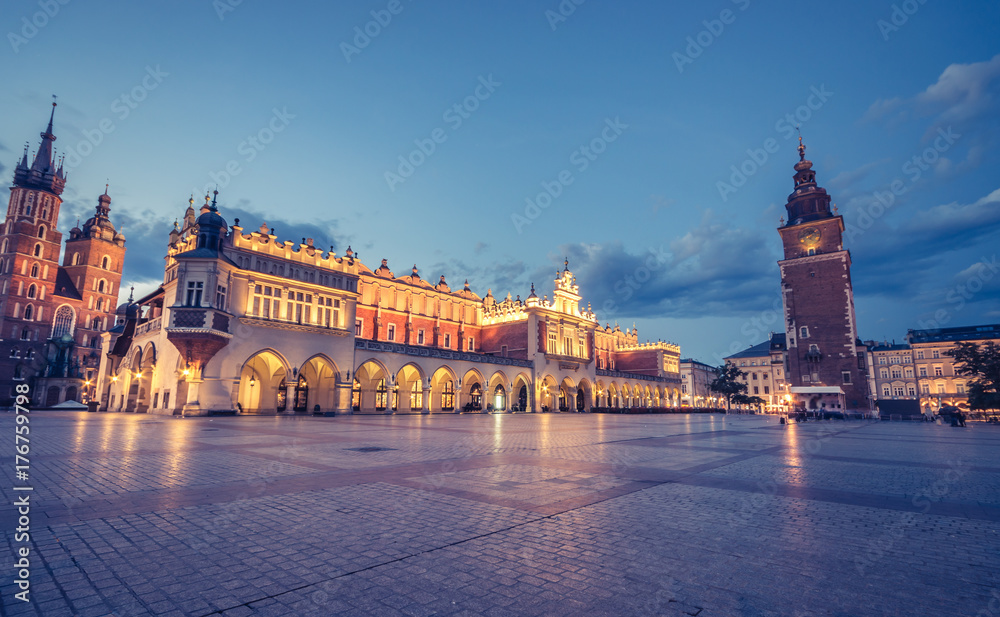Naklejka premium Kościół Mariacki, Sukiennice i wieża ratuszowa na Rynku Głównym w Krakowie oświetlone o poranku