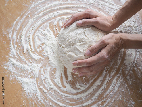 Female hands making dough for pizza 