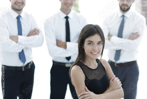 young employee of the company, standing in front of their colleagues.