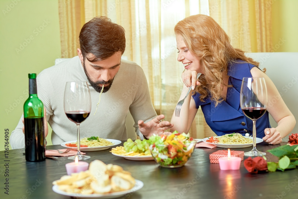 Young couple eating. Food and wine on table. What to order in restaurant. Young couple eating. Food and wine on table. What to order in restaurant.